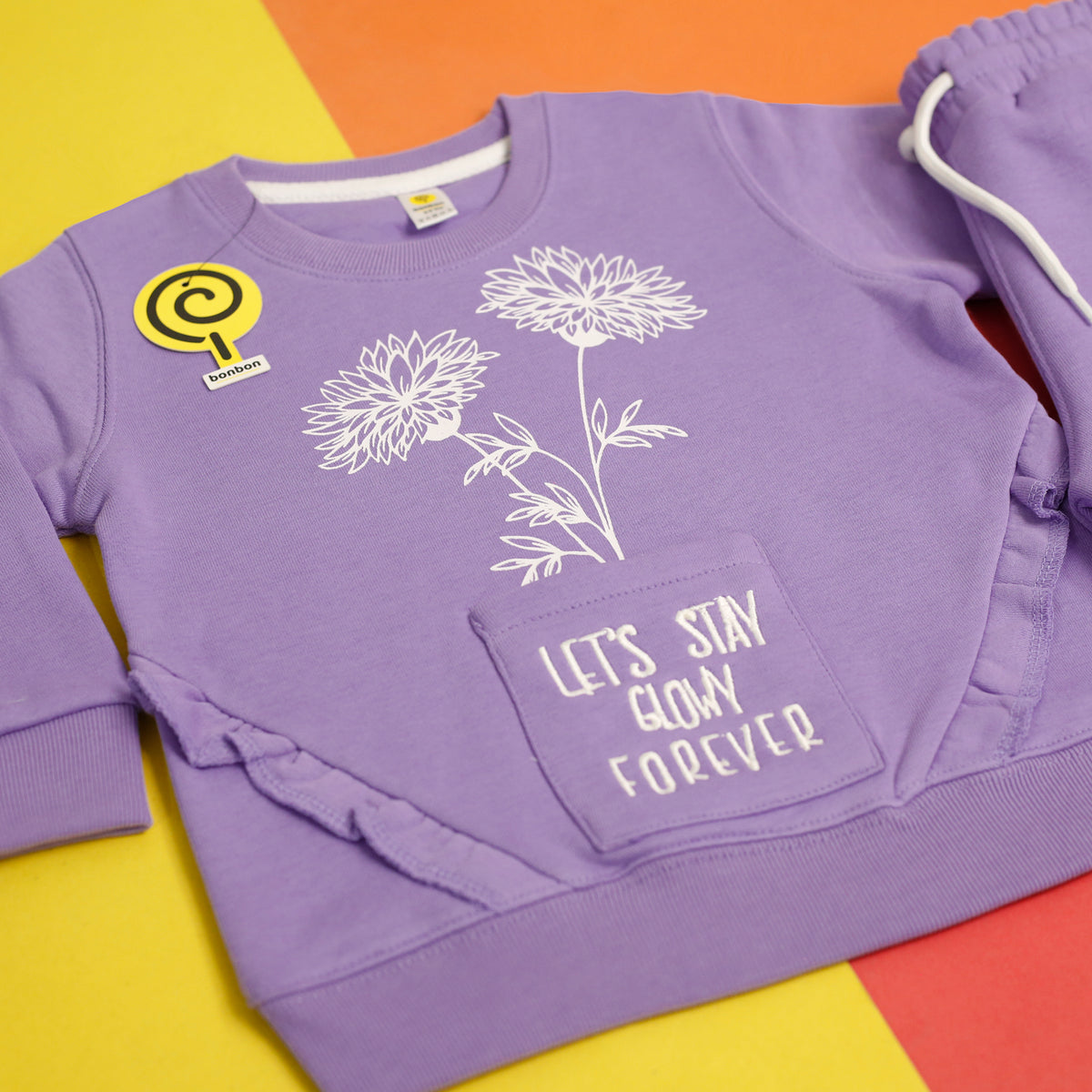Glowy lavender tracksuit flower print, pocket and ruffle trim close up